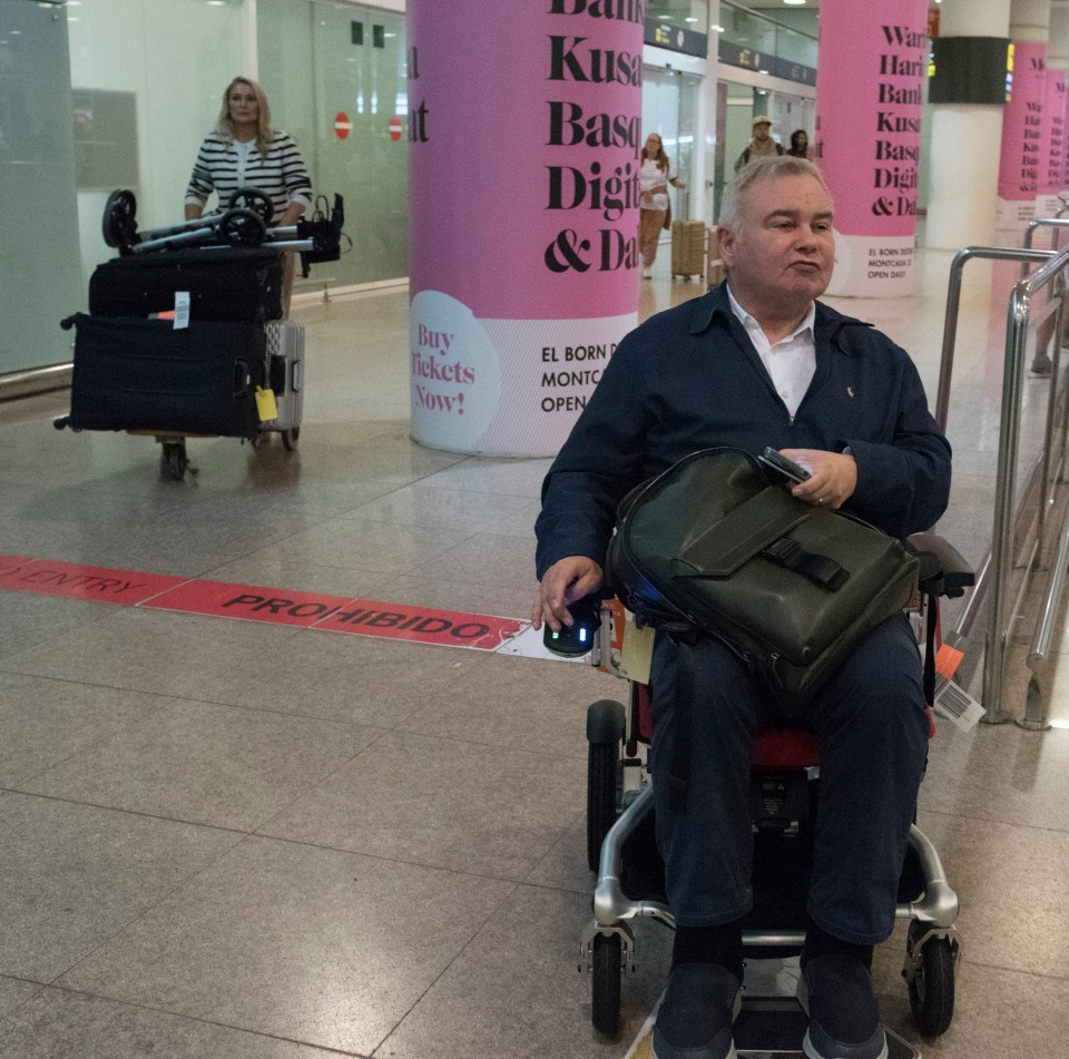 a man in a wheelchair in front of a sign that says prohibido