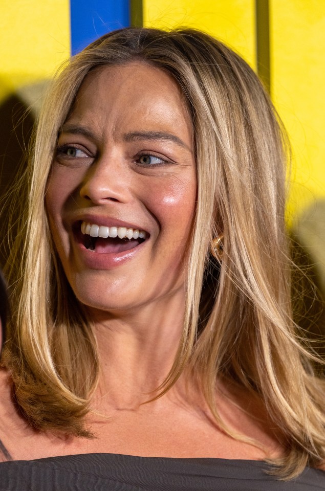 a woman with blonde hair is smiling with her mouth open