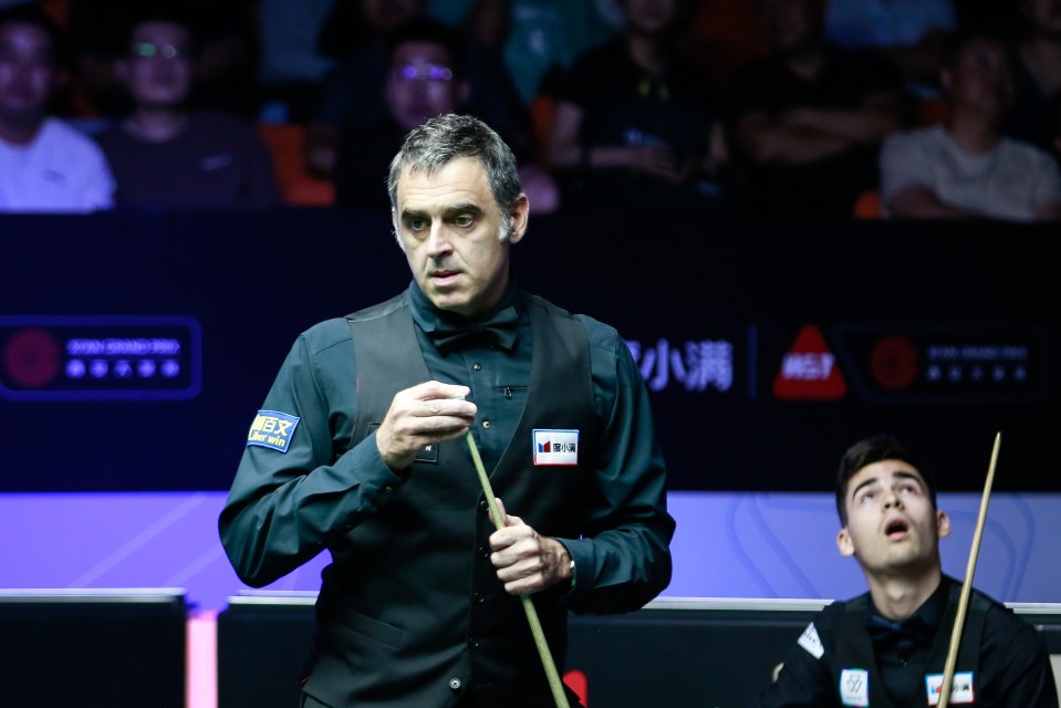a man holding a cue stick has a sticker on his vest that says bsx