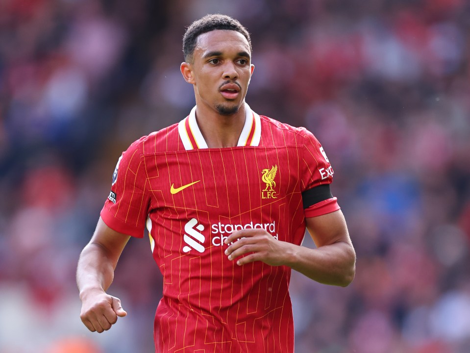 a soccer player wearing a red jersey that says standard chartered on it