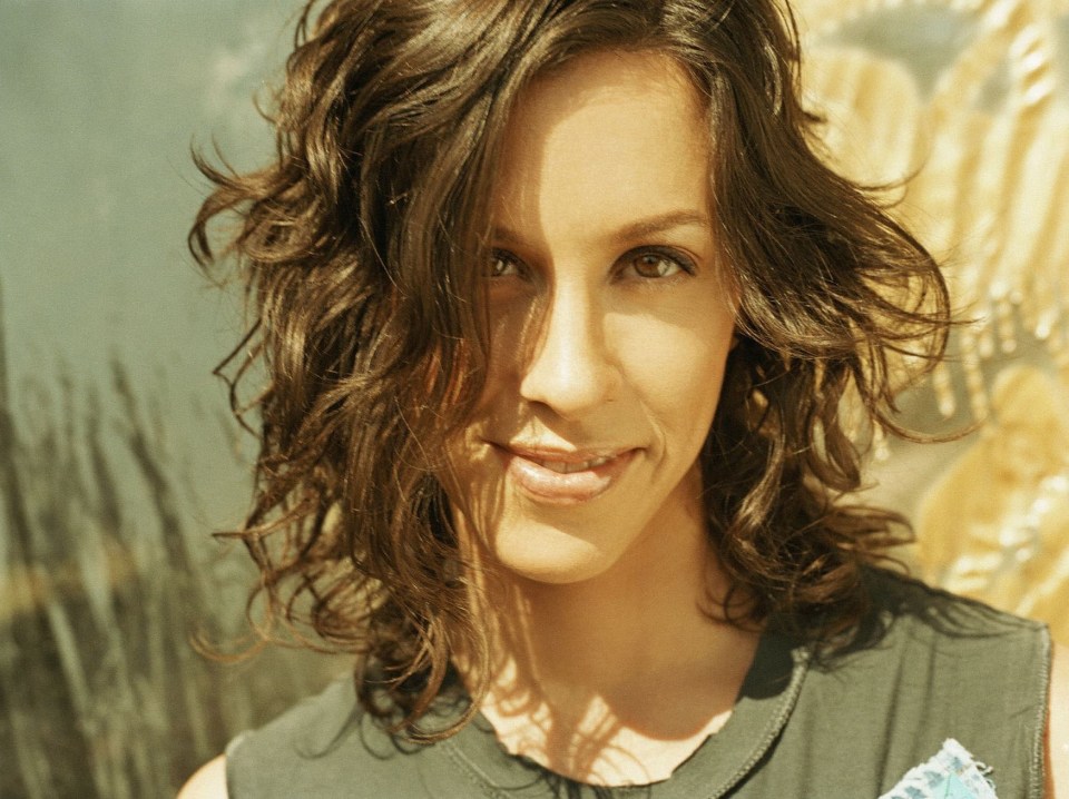 a woman with curly hair is smiling in front of a sign that says dar