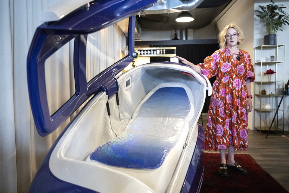 a woman in a floral dress is standing next to a machine
