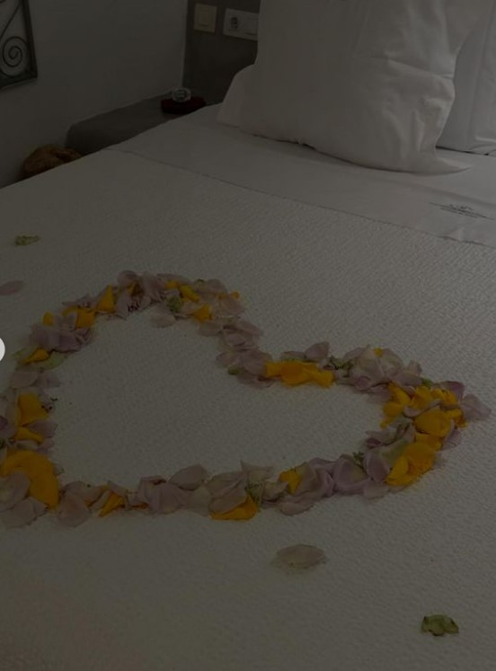 a heart made out of flower petals on a bed