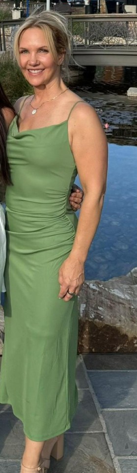 a woman in a green dress is standing in front of a body of water .