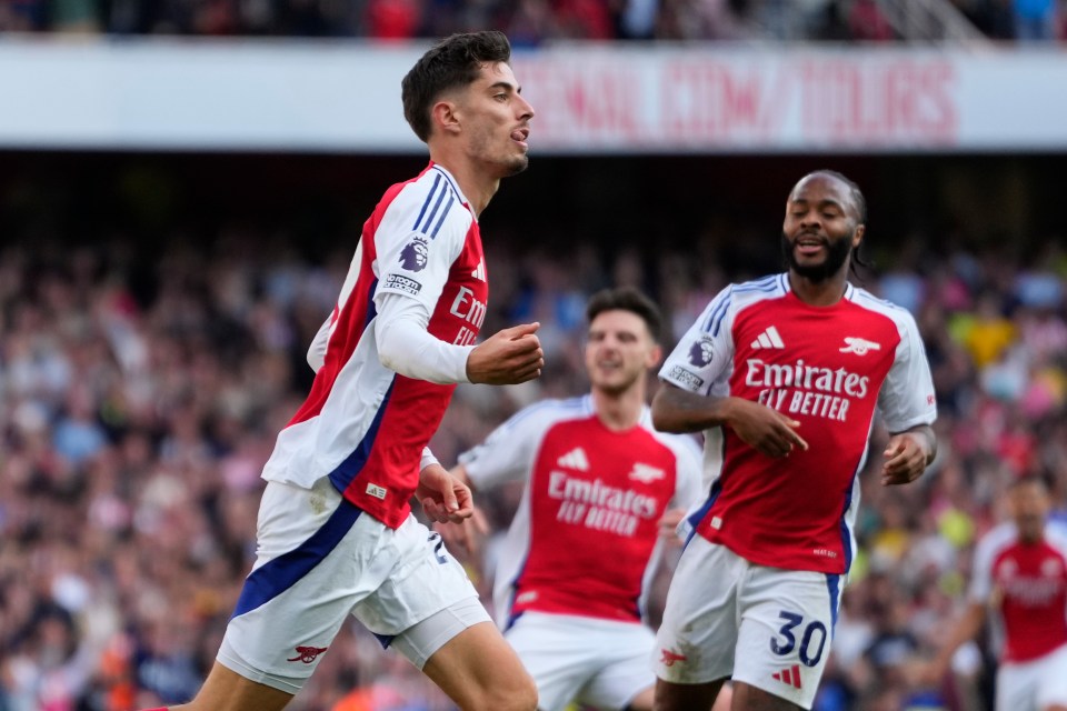 soccer player wearing a jersey that says emirates fly better