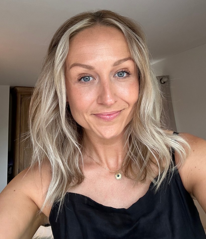 a woman with blonde hair and blue eyes wearing a black tank top