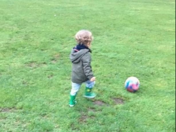 a little boy playing with a ball in a field with the words the juggle written on the grass