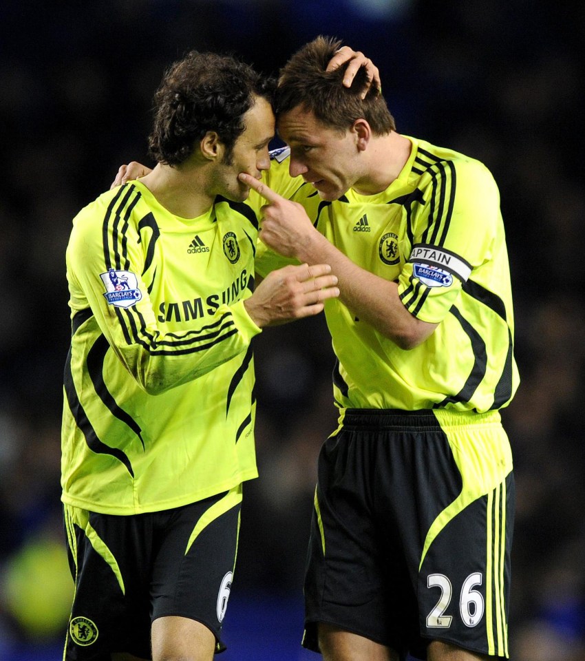 two soccer players are hugging and one has the number 26 on his shorts