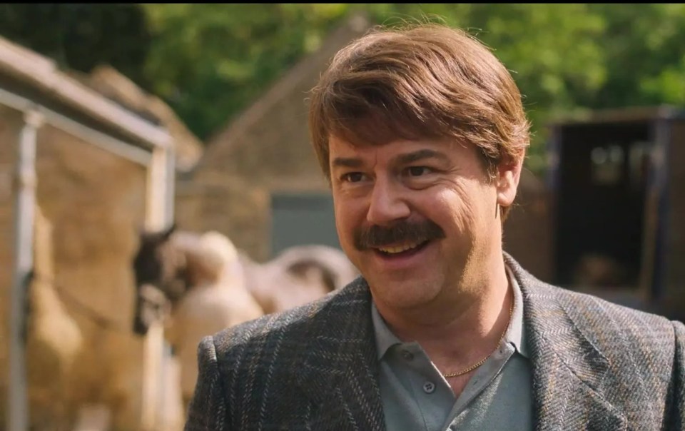 a man with a mustache is smiling in front of a sign that says parental advisory advised