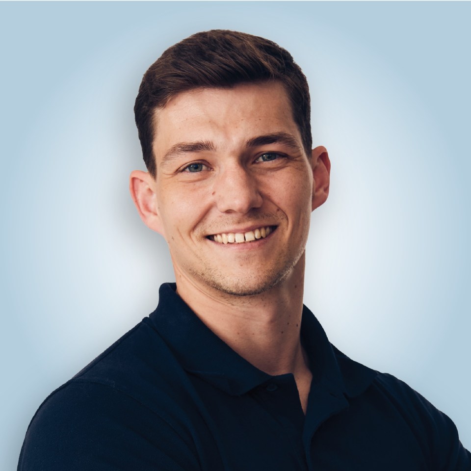 a man in a blue shirt smiles for the camera