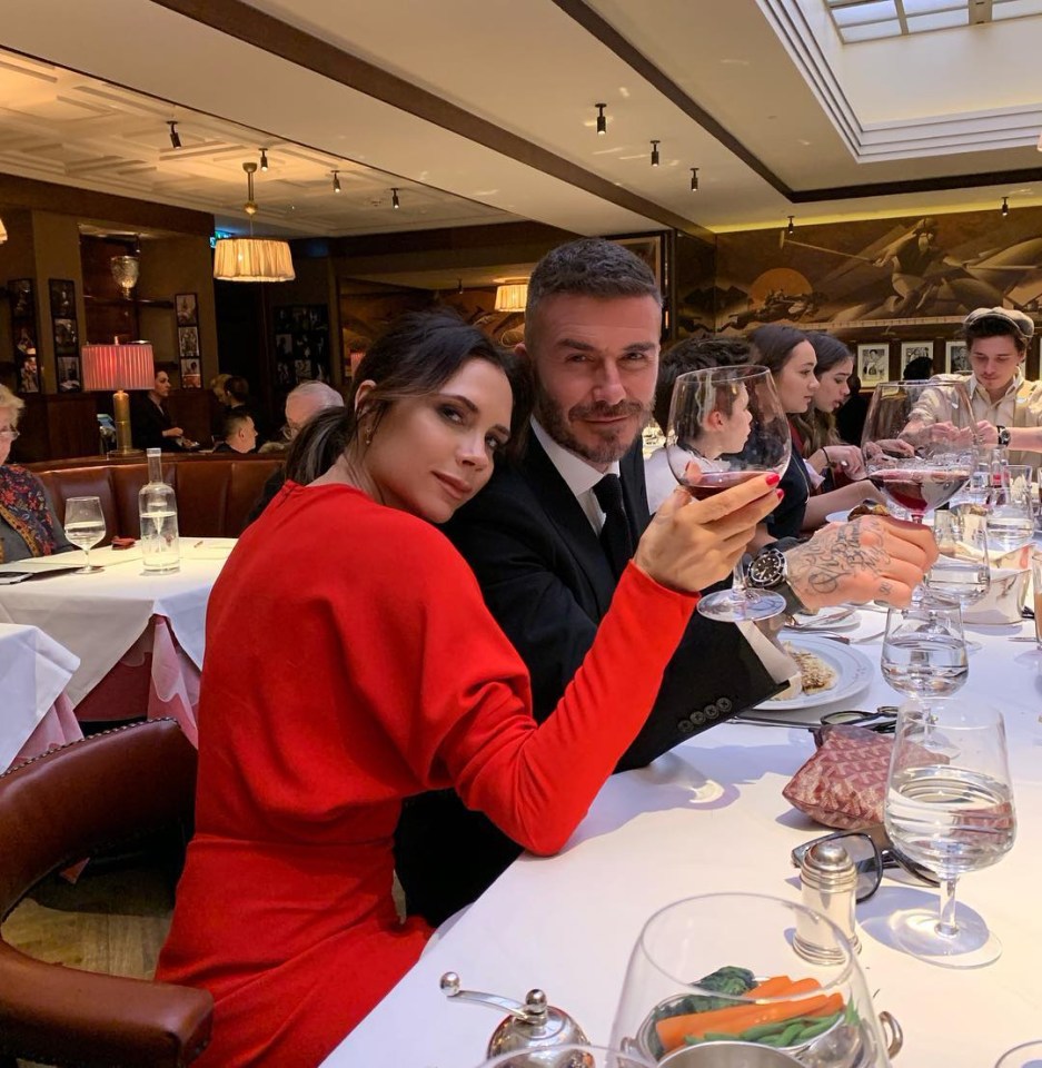 a man and woman sitting at a table holding wine glasses