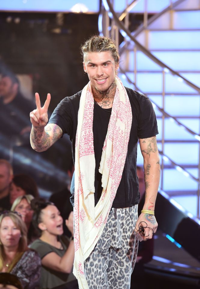 a man with a scarf around his neck giving a peace sign