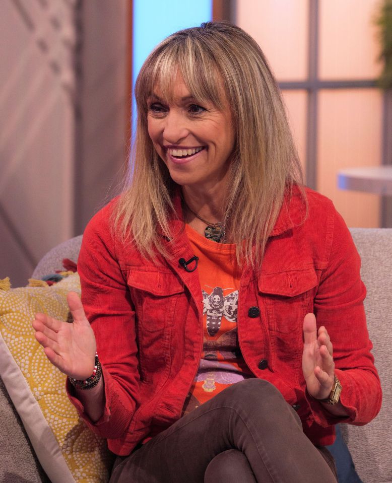 a woman in a red jacket is sitting on a couch