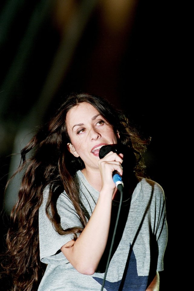 a woman with long hair singing into a microphone