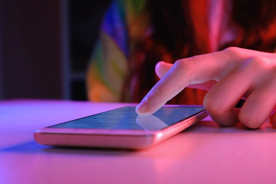 a person 's finger is pressing a button on a cell phone