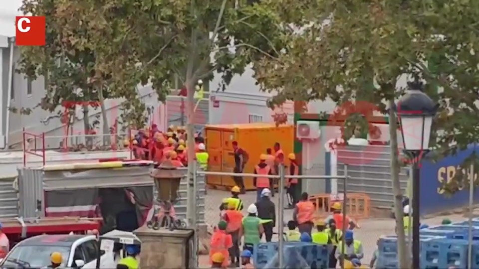 a group of construction workers are gathered in front of a building with the letter c above them