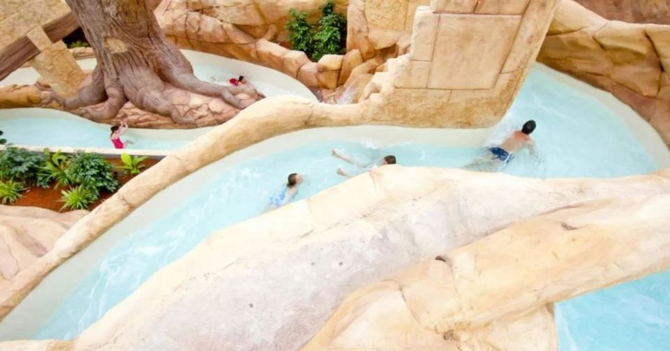 a group of people are swimming in a water park