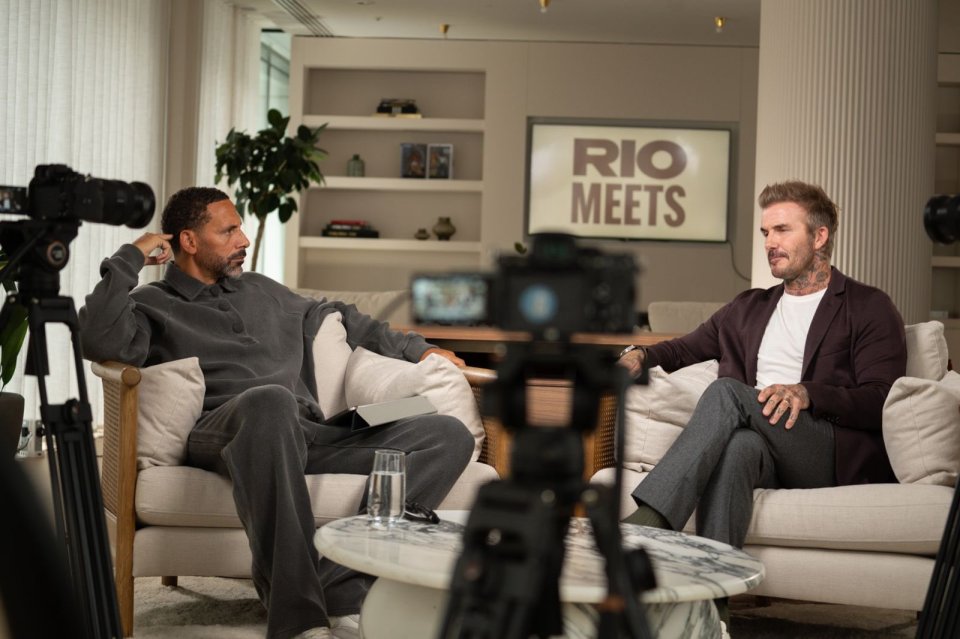 two men are sitting in front of a sign that says rio meets