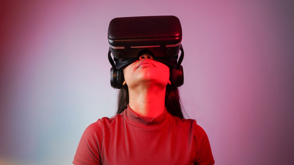a woman wearing a virtual reality headset and headphones