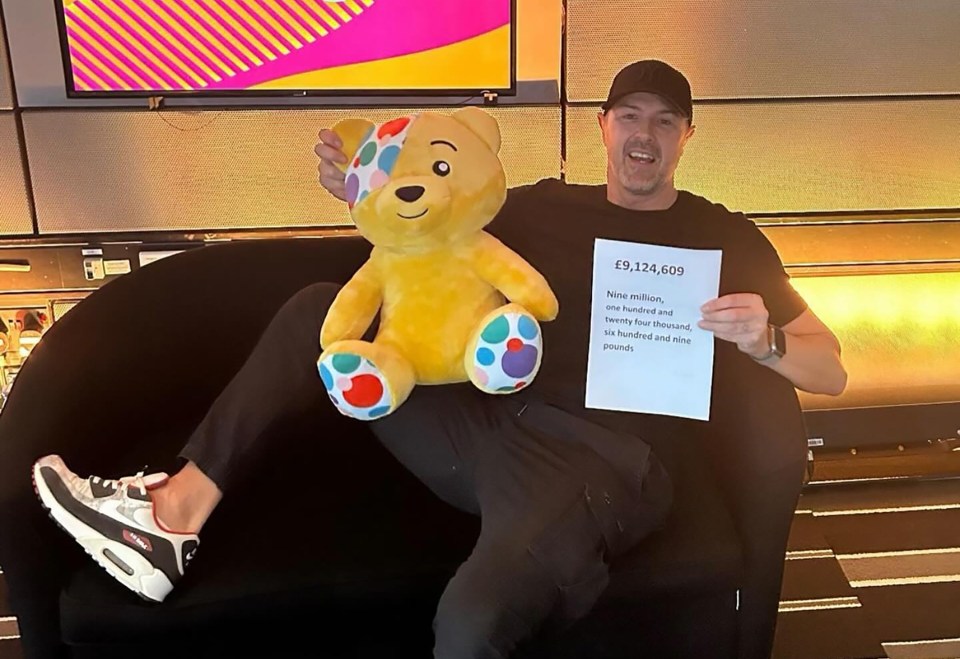a man is sitting on a couch holding a teddy bear and a sign that says £ 9,124,609 and counting