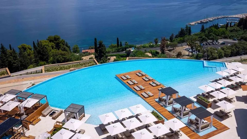 a large swimming pool is surrounded by umbrellas and chairs