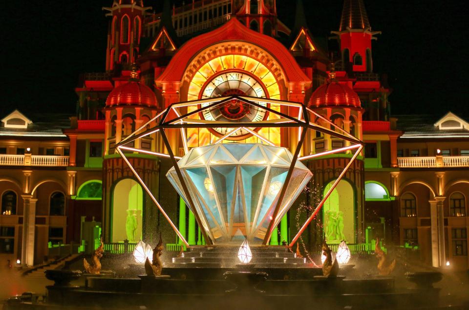 a large diamond shaped fountain in front of a large building