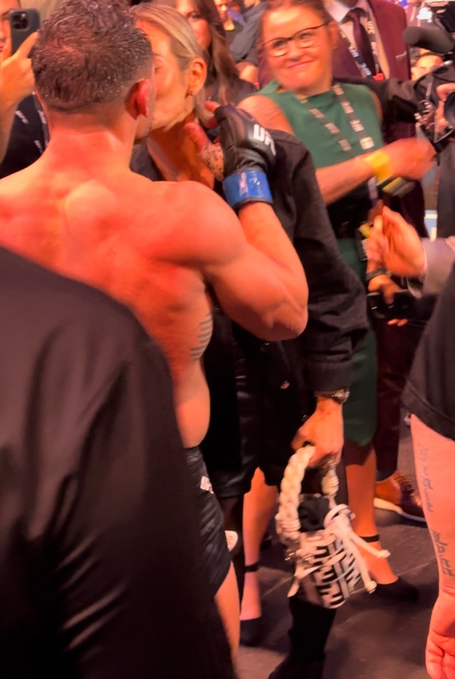 a man kisses a woman while wearing a ufc glove