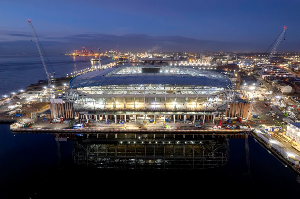 Aerial view of the new Everton Stadium under construction at night.