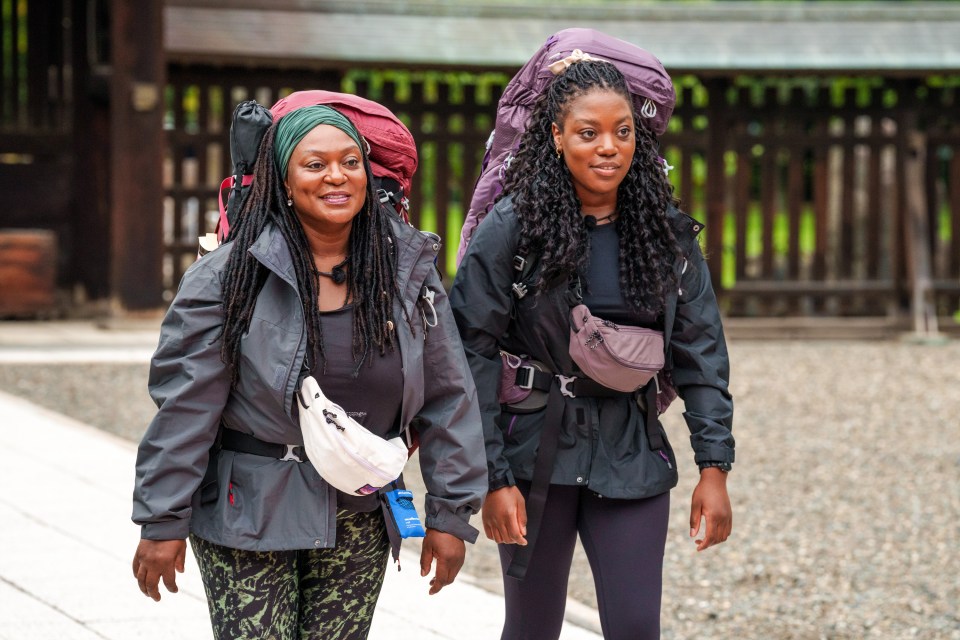 two women are walking with backpacks and one has a white fanny pack that says ' salomon ' on it