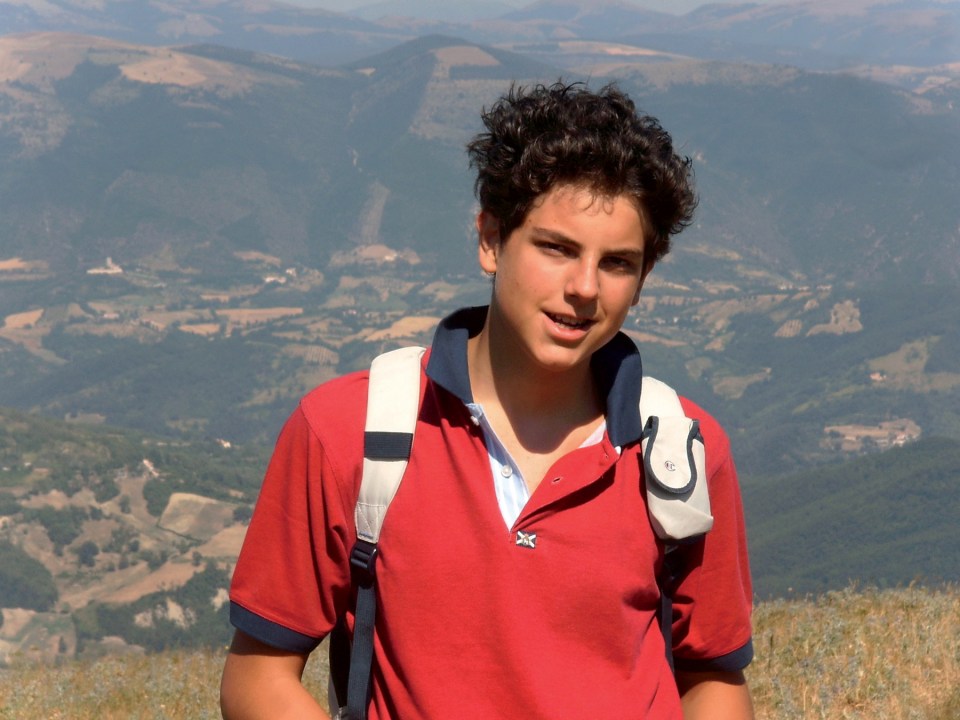 a young man wearing a red shirt with the letter x on it