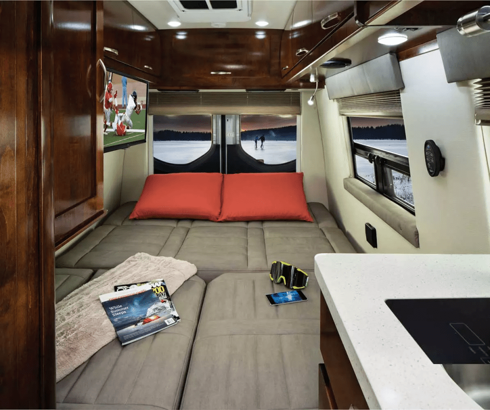 the inside of a camper van with a magazine on the bed