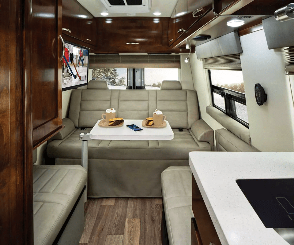 the inside of a van with a table and a tv