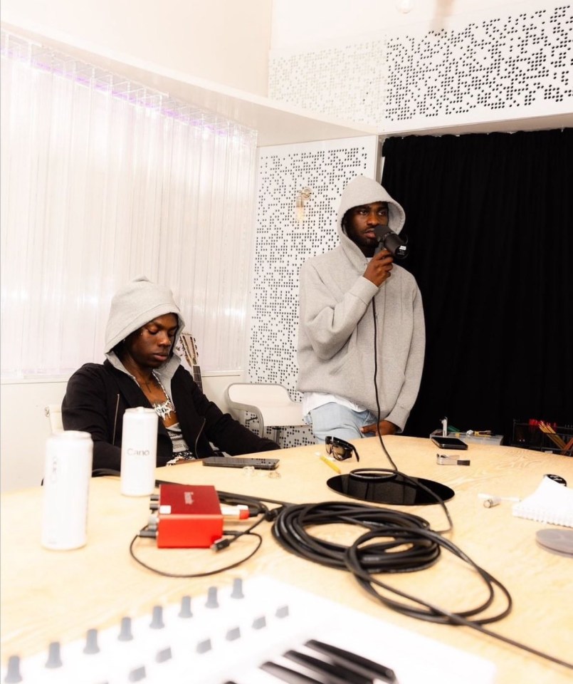 a man in a grey hoodie is holding a microphone