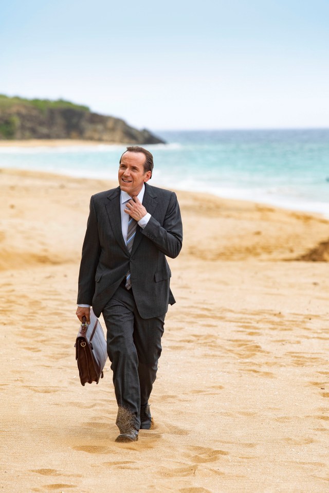 a man in a suit and tie is running on the beach