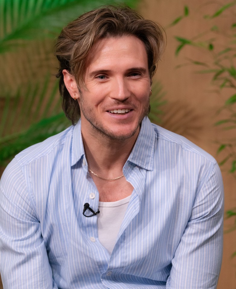 a man in a blue striped shirt has a microphone on his collar