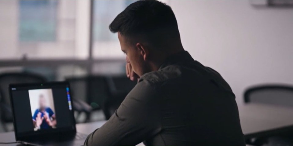 a man sitting in front of a laptop with a blurred image on the screen
