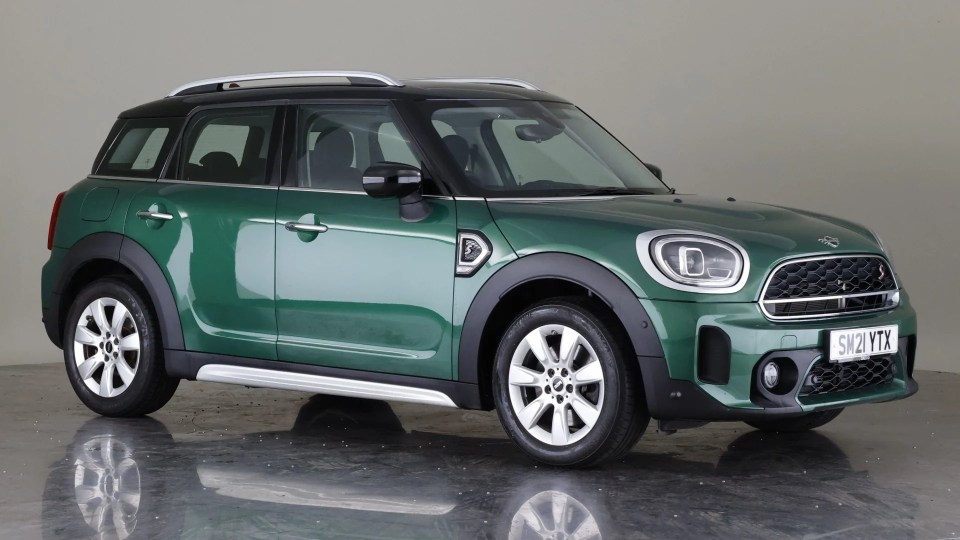 a green mini cooper with a license plate that says sm21vtx