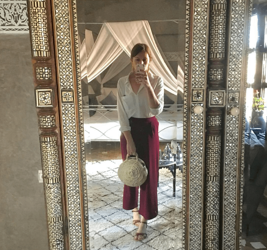 a woman taking a picture of herself in a mirror