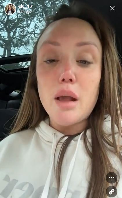 a woman is sitting in a car with her eyes closed and her mouth open .