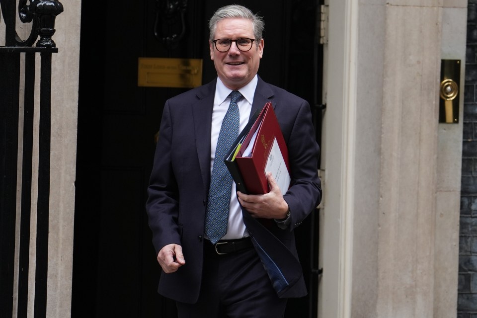 a man in a suit and tie is holding a red folder