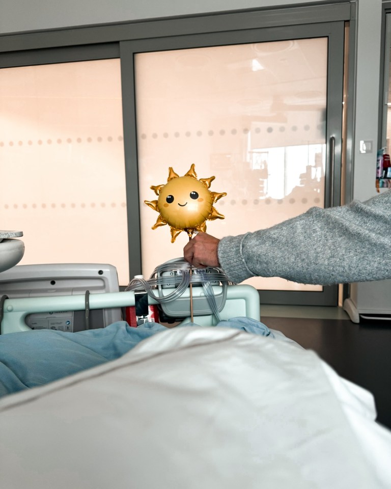 a person holding a balloon in the shape of a sun