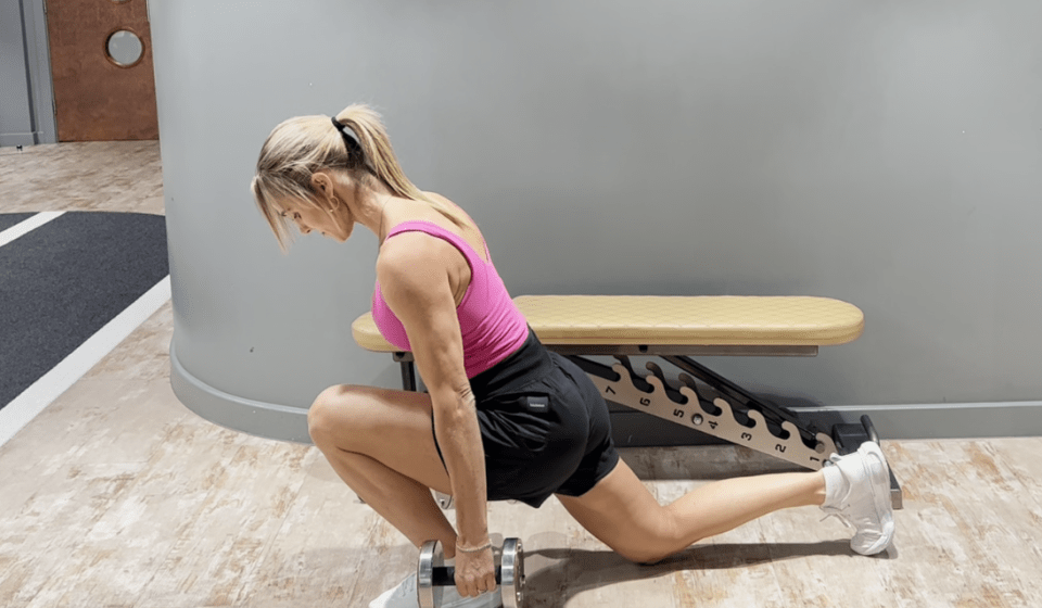 a woman squatting down with a dumbbell in front of a bench with the numbers 1 2 and 3 on it