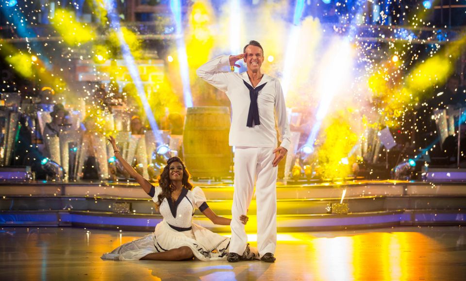 a man in a sailor 's uniform salutes a woman on a dance floor