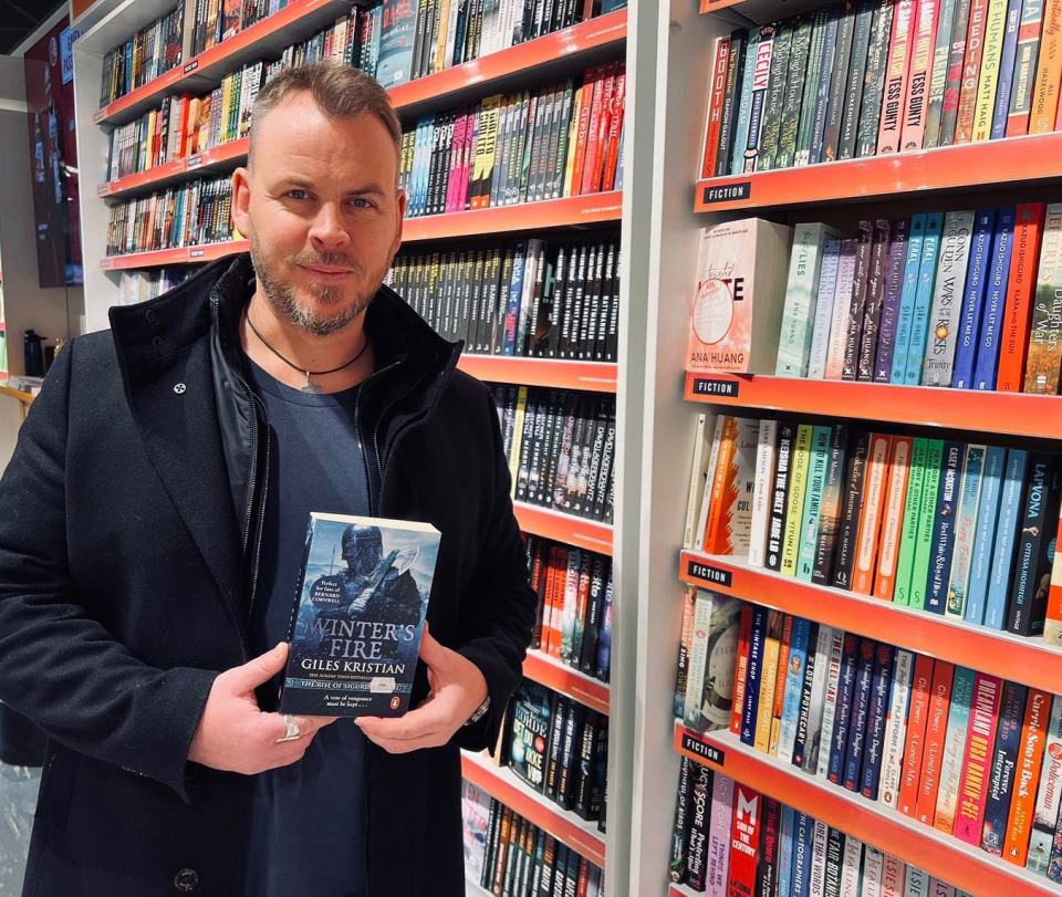 a man holds a copy of the winters tale by giles kristjan