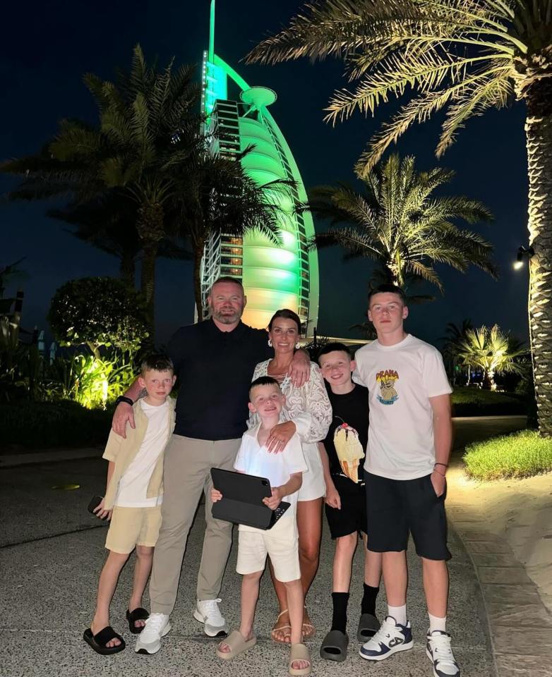 a family posing for a picture in front of a building that says prada