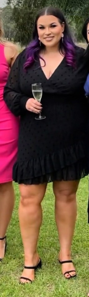 Woman with purple hair holding a glass of champagne.