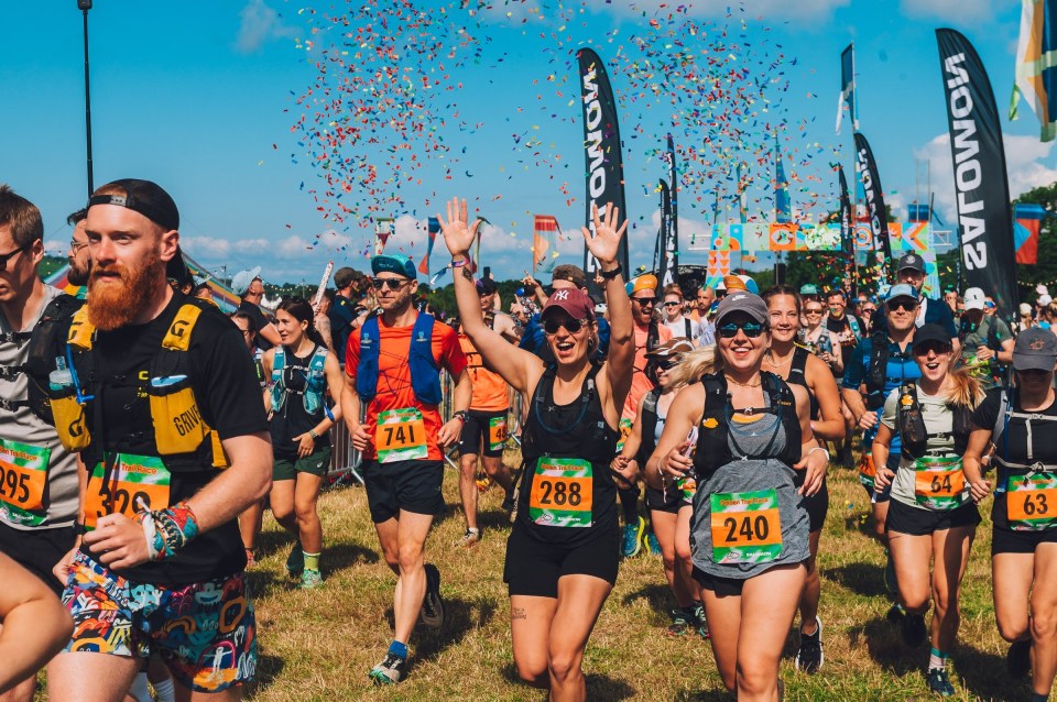 Trail runners finish a race, confetti falling.