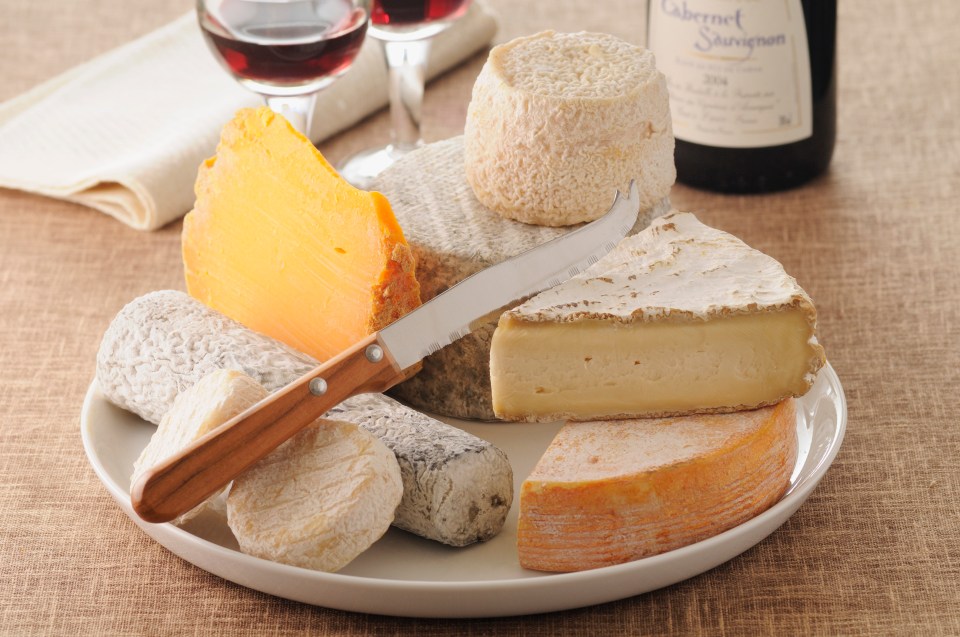 Assortment of French cheeses and red wine.
