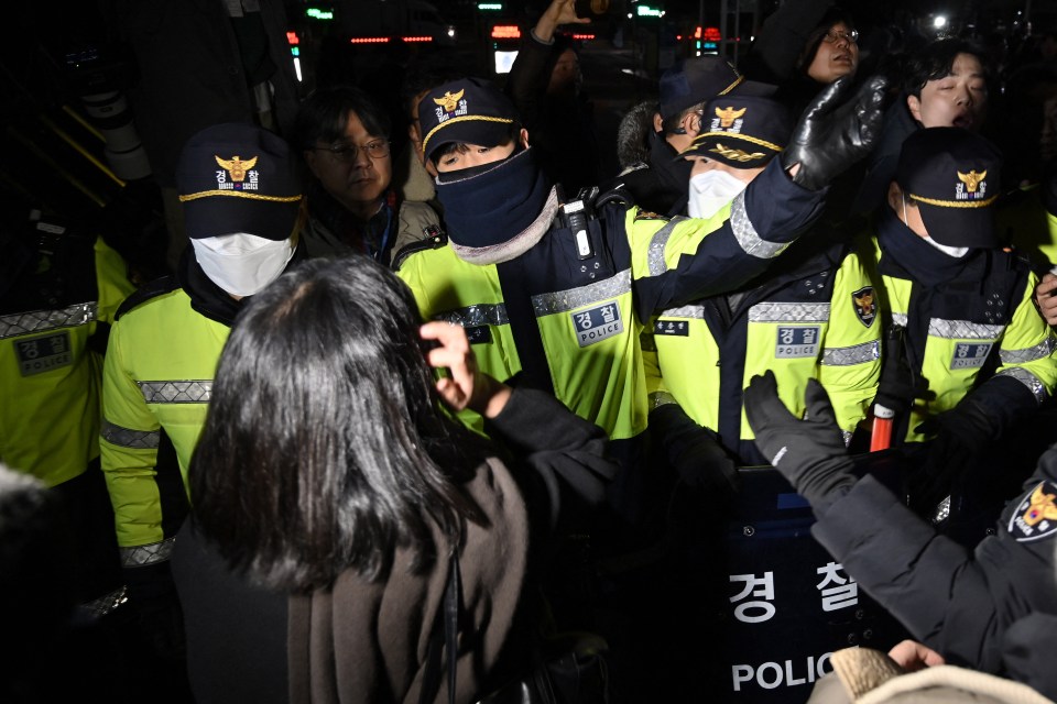 Cops try to hold back furious crowds trying to enter the main gate of the National Assembly