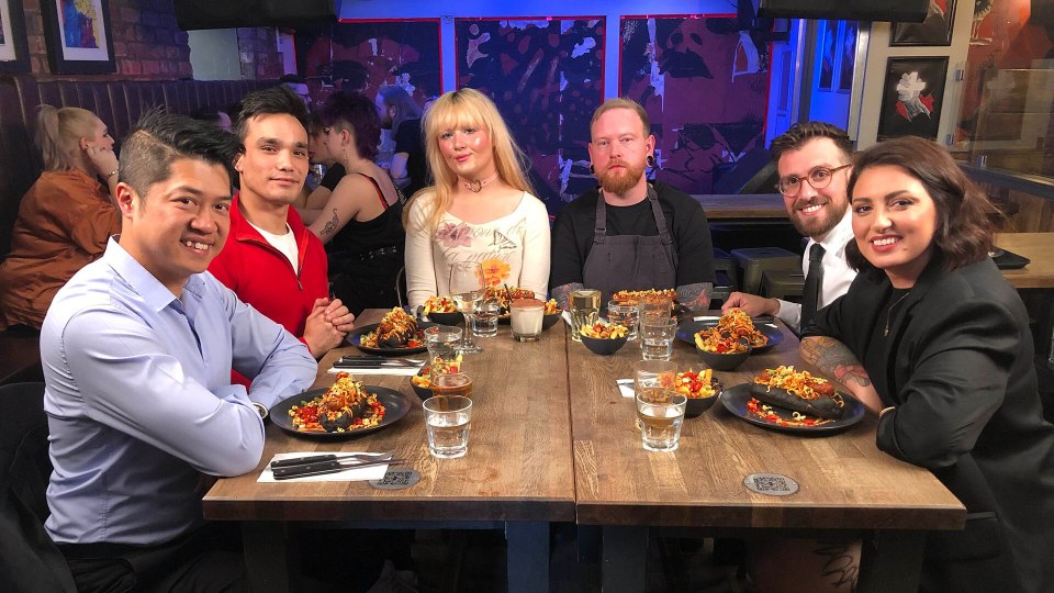 Six professionals seated at a table, enjoying a meal together.